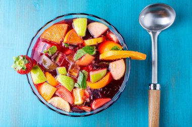 Meyveli, naneli ve buzlu bir kase, servis edilecek bir tencerenin yanında.. 