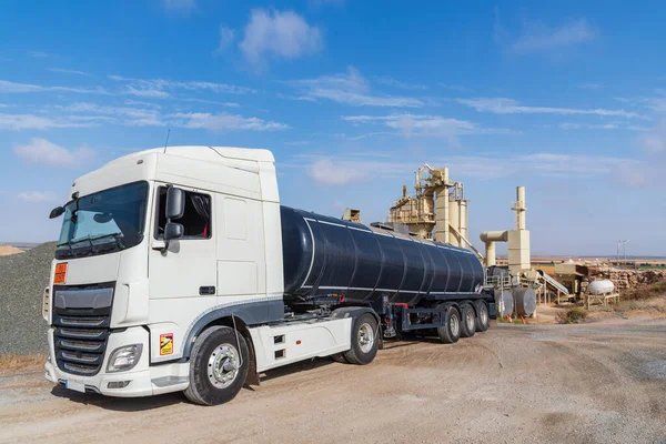 Tanker truck loaded with high temperature bitumen entering an agglomerated asphalt manufacturing plant.