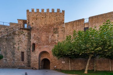 Door in the high wall under the clock tower in Buitrago de Lozoya