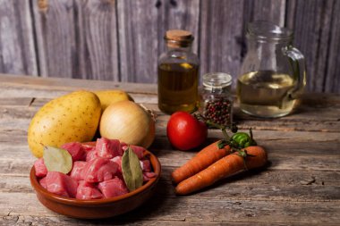 Sığır eti güveci, patates, soğan, biber, havuç, domates, yağ, defne ve beyaz şarap için gereken malzemeler..