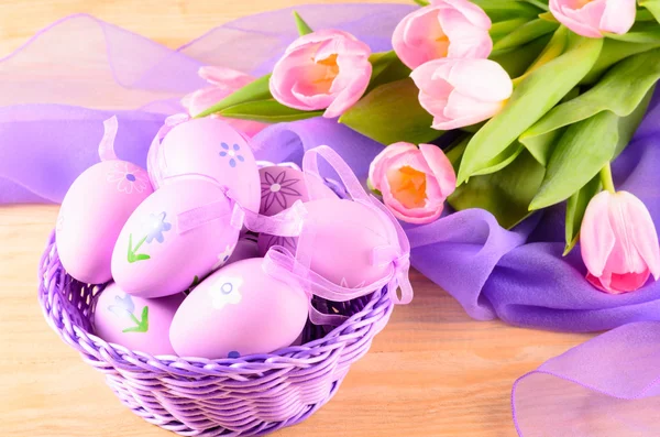 Ovos decorativos de Páscoa na cesta e tulipas — Fotografia de Stock