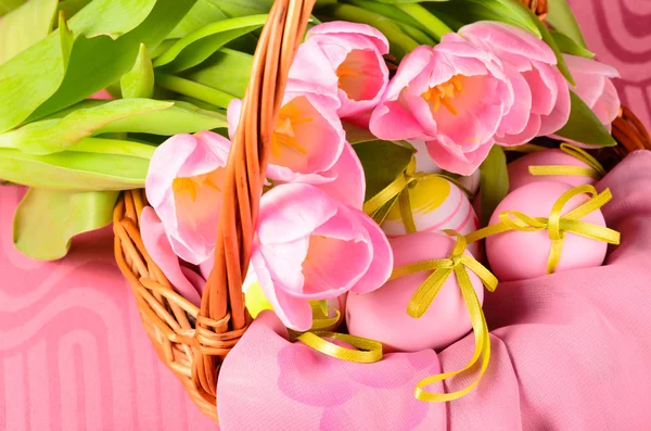 Decoratieve paaseieren in de mand en tulpen — Stockfoto