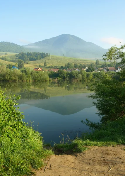 Village dans la brume du matin avec étang et collines — Photo