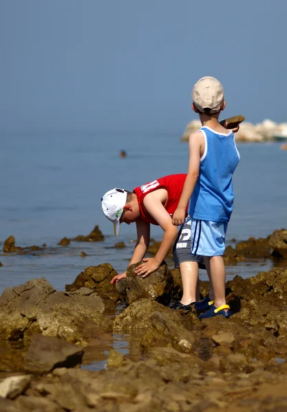 Two boys playing on a stone beach — Stock Photo, Image