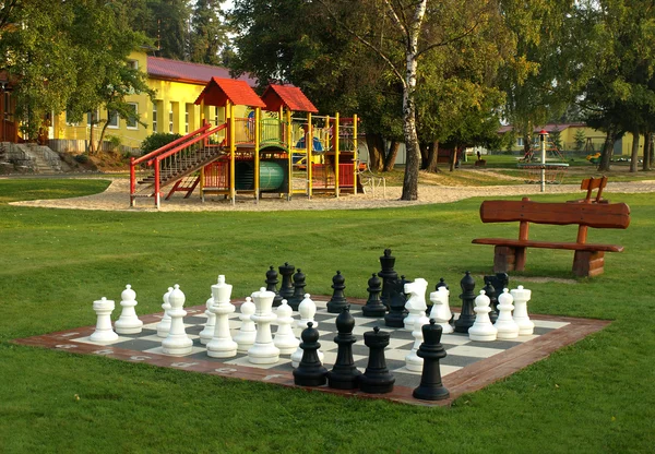 Parque infantil en el sol de la mañana con un ajedrez — Foto de Stock