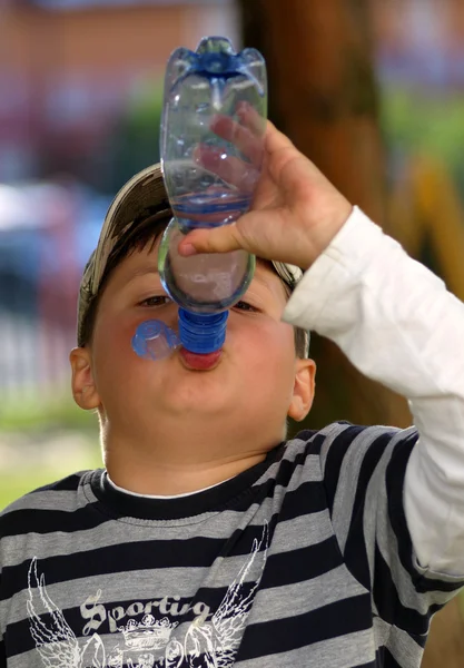 Niño sediento que bebe agua de la botella — Foto de Stock