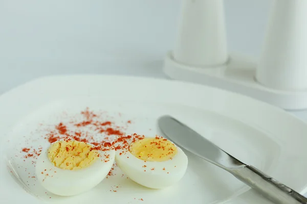 Hard boiled eggs sliced halves in white plate — Stock Photo, Image