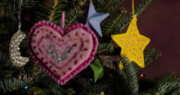 从粉红的自制心形装饰品到常绿圣诞树上的黄星装饰品的齿条焦点 — 图库视频影像