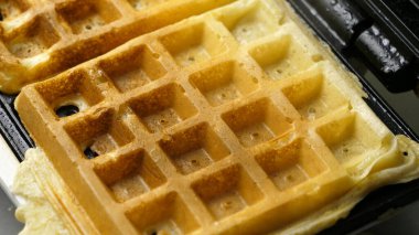 A homemade waffle finished baking on a waffle iron