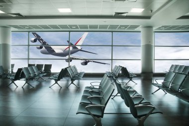 Arka planda uçak olan boş havaalanı kalkış salonu.