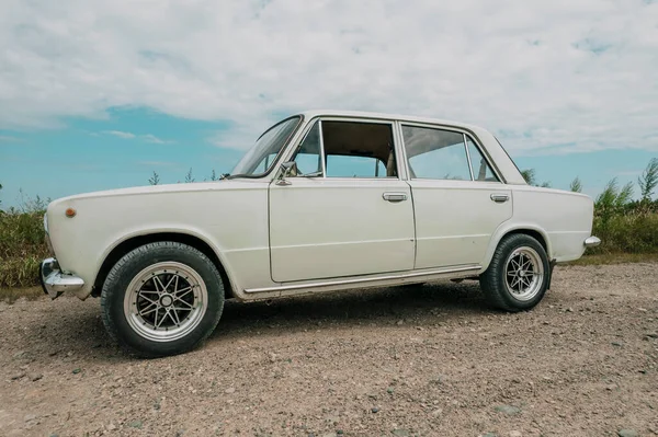 Russian old Lada car, white, on the background of the field — Stockfoto