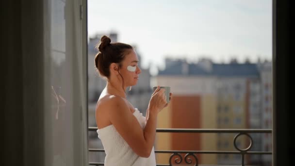 Bir kadın tatmin edici bir kahveyi yudumlar ve zihninin sabahları evinin balkonunda düşünmesini sağlar. — Stok video