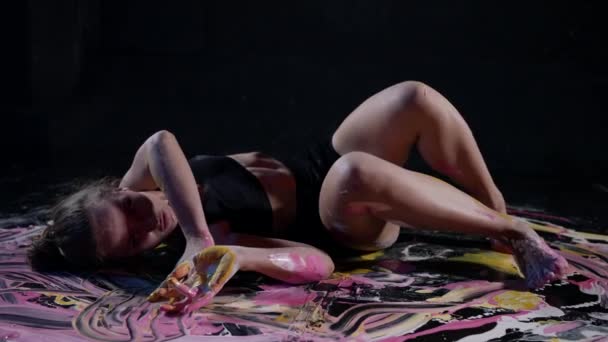 Doświadczony artysta improwizacji porusza się w transie na podłodze w rozlanej, wielobarwnej farbie — Wideo stockowe