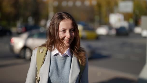 Slow-motion vooraanzicht van een leuke volwassen dame lopen in een stad straat, glimlachen naar de camera — Stockvideo