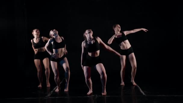 Un grupo de bailarines tiene el concepto de bailar en cámara lenta sobre un fondo negro — Vídeo de stock