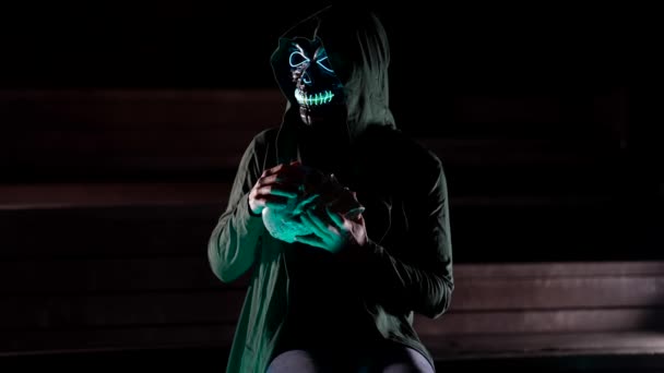 Escena de horror o decoración de Halloween imagen de la muerte en la noche con un cráneo en sus manos — Vídeos de Stock