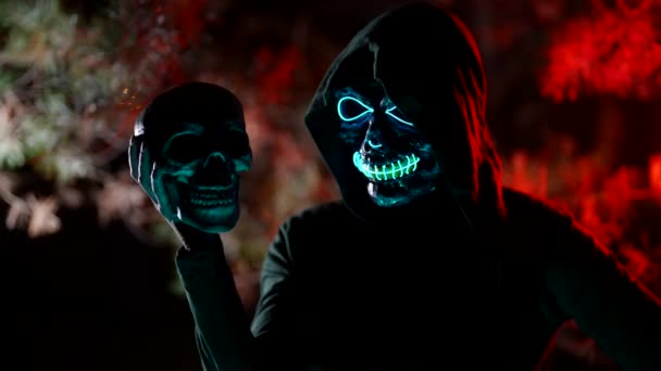 Close-up portrait of a female face in a death mask. Halloween Costume party holding a skull in your hands — Stock Video