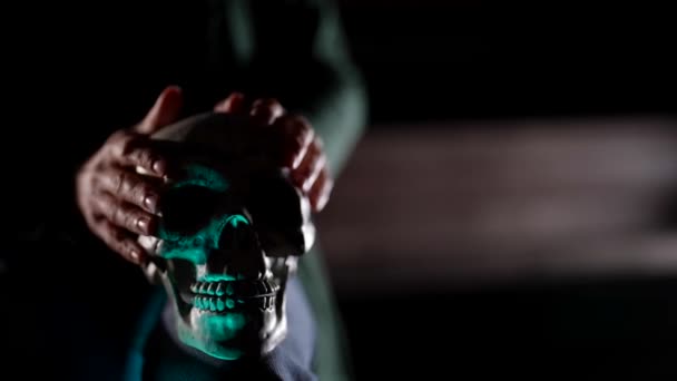 Close-up of a hand holding a human skull. A fortune teller performing a ritual rite with the remains of bones for witchcraft. — Stock Video