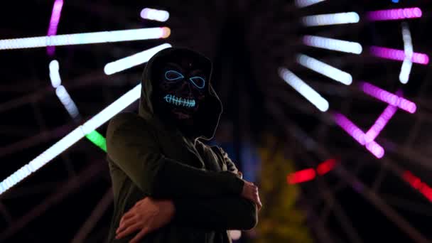 Retrato de arte espeluznante máscara de muerte en luces de neón de la ciudad Parque de Atracciones — Vídeo de stock