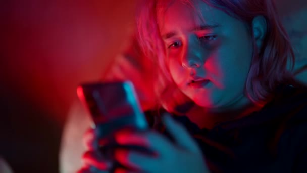 Девочка-подросток, зависимая от интернета, не может спать и сидит ночью в постели с телефоном — стоковое видео