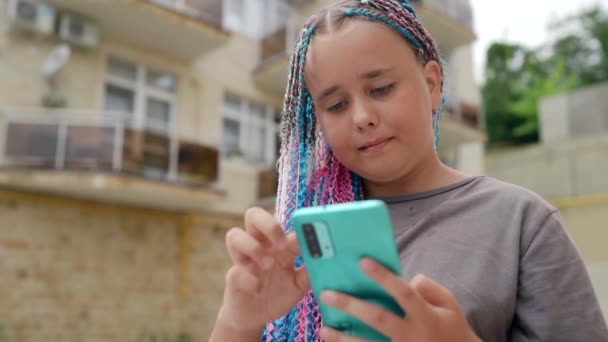 Грустная одинокая девушка-подросток с телефоном скучает в социальных сетях — стоковое видео