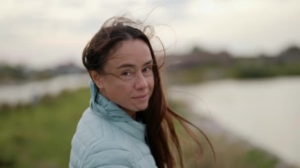 Retrato de close-up de uma turista ativa, com cabelos longos, no vento em movimento — Vídeo de Stock