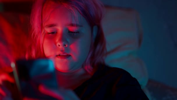 Un adolescente dipendente da Internet di notte a letto utilizza il telefono per i videogiochi online — Video Stock