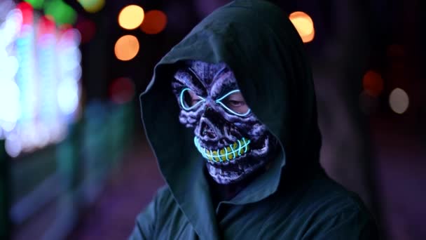 Ett läskigt porträtt i en dödsmask på halloweenfesten i nöjesparken. — Stockvideo