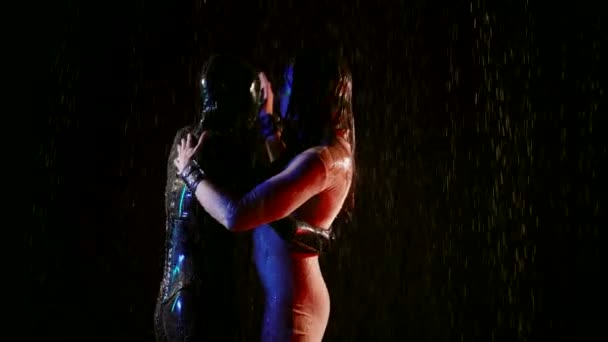 Performance artistique deux fétichistes dansent en costumes la nuit sous la pluie. Un couple homosexuel est une expression de sentiments dans l'improvisation des actions. — Video