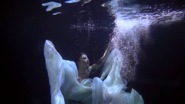 Une fille danse sous l'eau dans une piscine équipée pour filmer des vidéos et des photos. Une jeune fille montre des mouvements au ralenti — Video