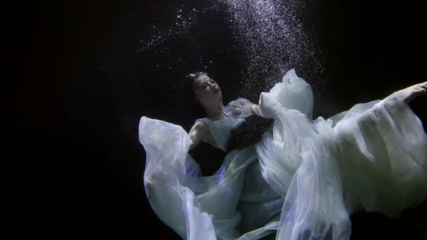 Una joven bajo el agua es como una sirena, lleva un vestido blanco.. — Vídeo de stock