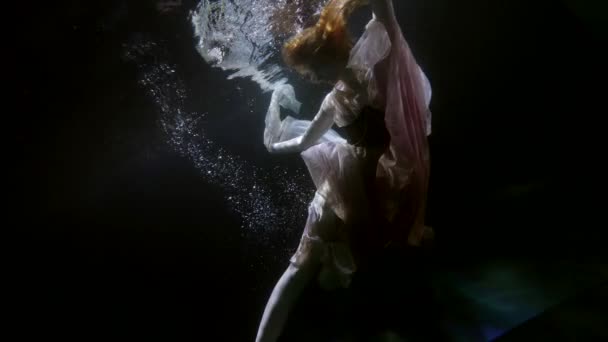 Aantrekkelijke vrouw in een witte jurk poseren onder water in het zwembad — Stockvideo