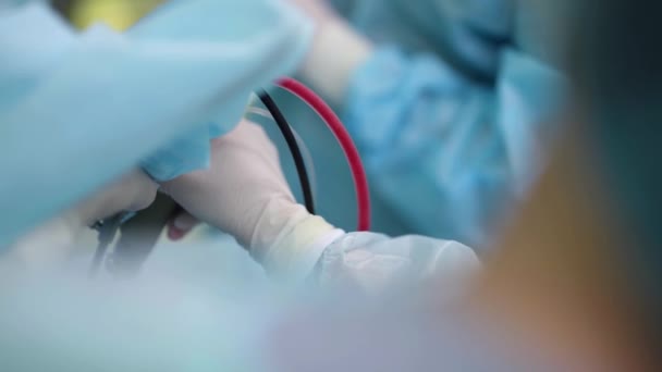 Medico o tirocinante sta pompando sangue dalla cavità operatoria del paziente durante l'intervento chirurgico — Video Stock