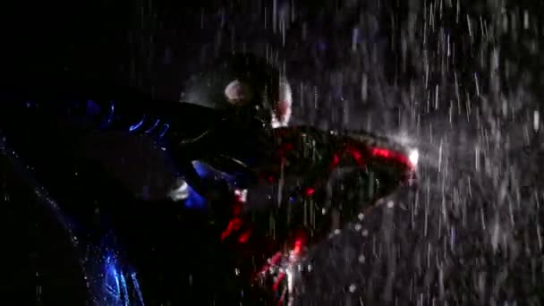 Sexy dama en negro látex bdsm traje es posando en la lluvia en la oscuridad — Vídeo de stock
