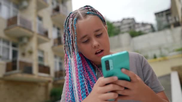 Милая девочка-подросток, использующая свой смартфон на городской улице. — стоковое видео