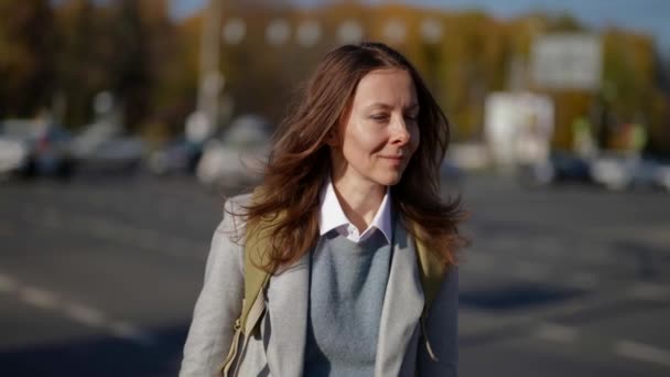 Charmante vrouw loopt in kleine stad in de zonnige herfstdag, portret van voorbijganger op straat — Stockvideo