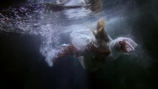 Uma jovem se aproxima do reflexo de seu rosto subaquático — Vídeo de Stock