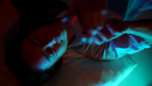 Žena se dívá na video na telefonu v noci, zatímco leží v posteli — Stock video