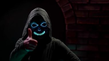 Maskeli bir kadının portresi. Karanlıkta, tuğla bir duvarın karşısında neon bir ölüm. Teneke bir el.