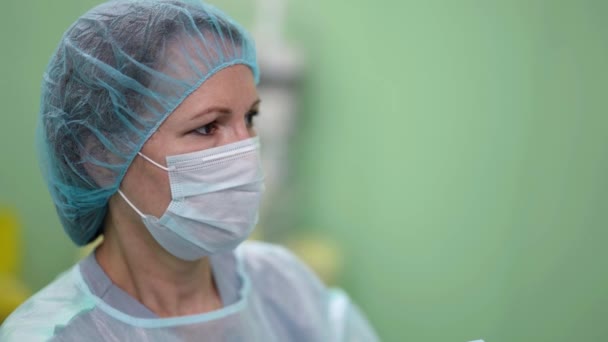 Porträtt av kvinnlig kirurg under operation i klinik, modern medicinsk teknik — Stockvideo