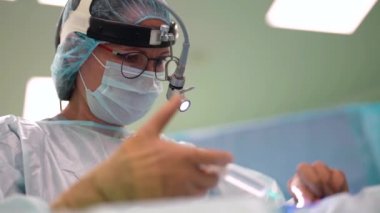 Doktor, hastaya ameliyat masası, anestezi ve antiseptik ilaçlar veriyor.