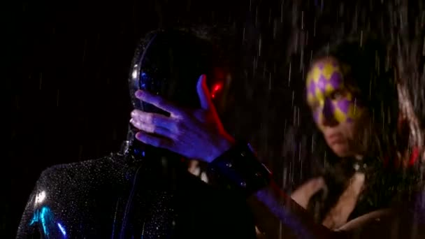 Дві сексуальні жінки пестять одна одну під дощем у темряві, мокрі жіночі тіла в бджільницьких костюмах — стокове відео
