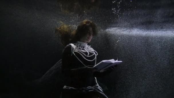 Sprookjesachtige middeleeuwse dame met parel ketting is het lezen van boek onderwater — Stockvideo