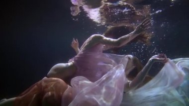 Yarı çıplak seksi kadın vücutları suyun altında, iki lezbiyen havuzda yüzüyor ve flört ediyorlar.