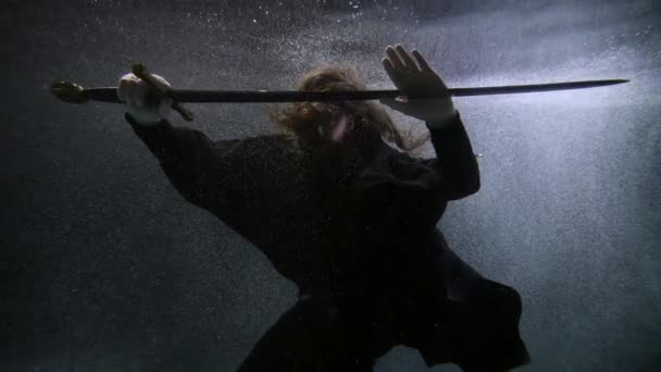 Man is fighting with black magic underwater, floating male figure in dark depth of ocean or river — Stockvideo