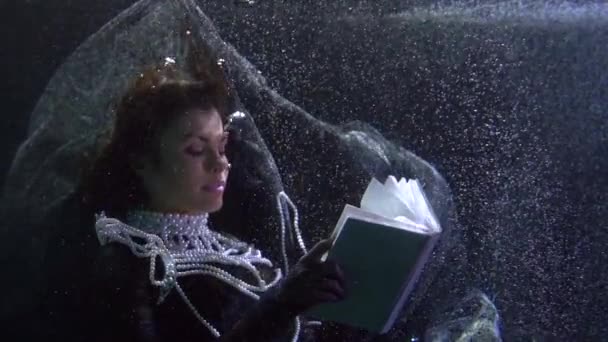 Романтическая средневековая леди с жемчужным ожерельем читает книгу, сюрреалистичный подводный портрет — стоковое видео