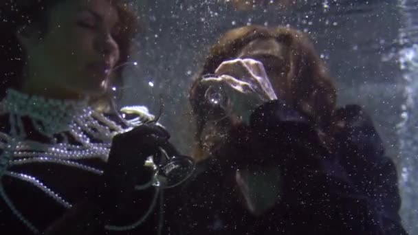 Hombre y mujer están coqueteando y bebiendo de vino bajo el agua, romántico y mágico — Vídeo de stock