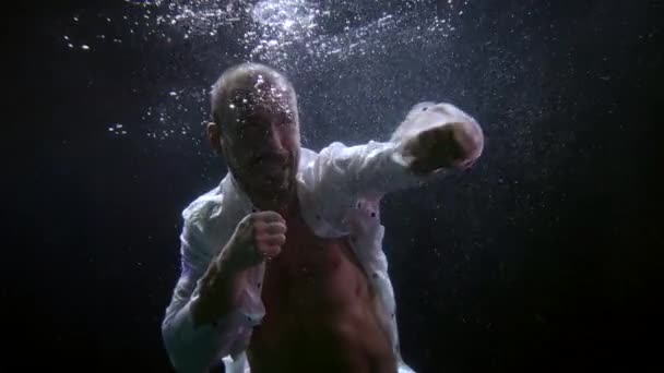 Portret van woedende agressieve man vecht met onzichtbare vijand onderwater, gespierde bokser — Stockvideo