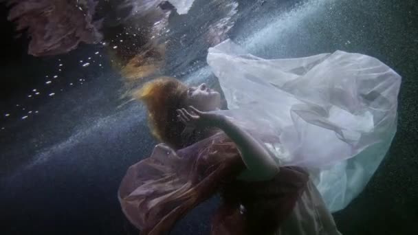 Romántica mujer solitaria está flotando bajo la superficie del agua en la piscina o el río, tiro submarino de la señora — Vídeo de stock