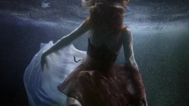 Graceful woman in silk dress is floating underwater, slow motion portrait inside water — Video Stock